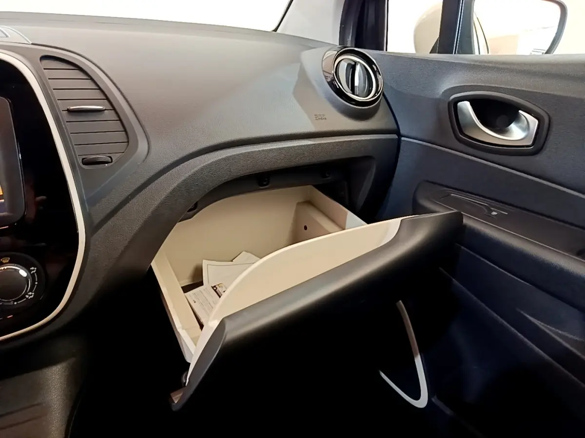 Vue intérieure côté passager du tableau de bord noir avec boîte à gants ouverte du Renault Captur Business TCe 90 2018.