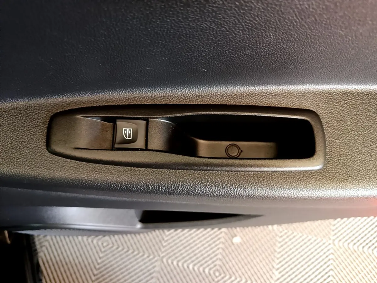 Détail de la commande de lève-vitre électrique côté porte intérieure d’un Renault Captur Business noir de 2018.