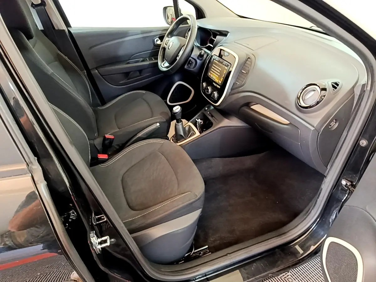 Intérieur avant droit de la Renault Captur Business TCe 90 noir, montrant sièges, volant cuir et tableau de bord tactile.