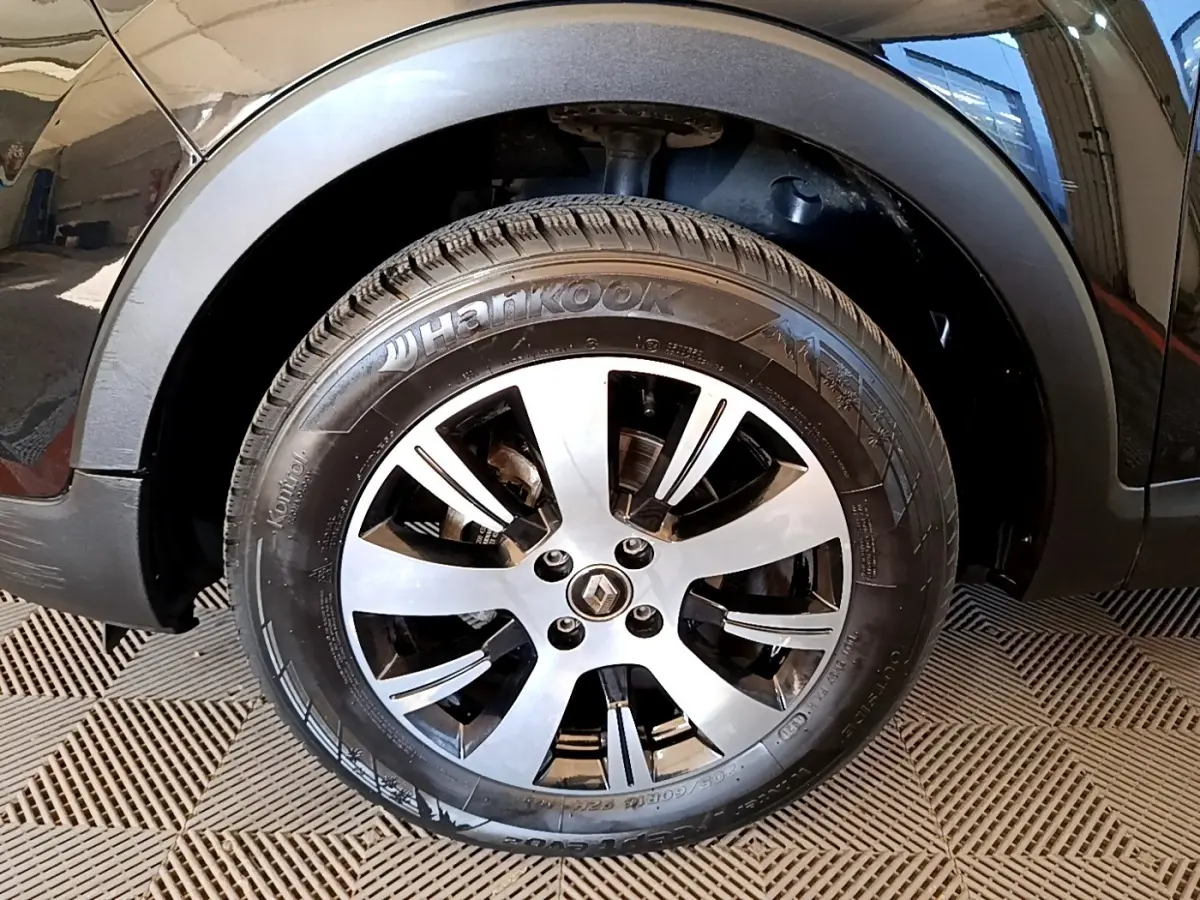 Gros plan sur la roue avant droite noire du Renault Captur Business TCe 90 avec jante alliage argentée.