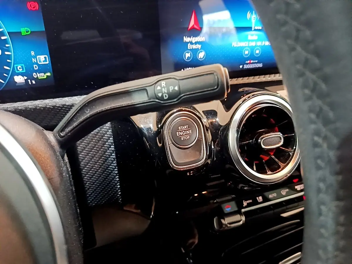 Gros plan intérieur sur le tableau de bord noir d’une Mercedes Classe A avec bouton start/stop et levier de vitesses.