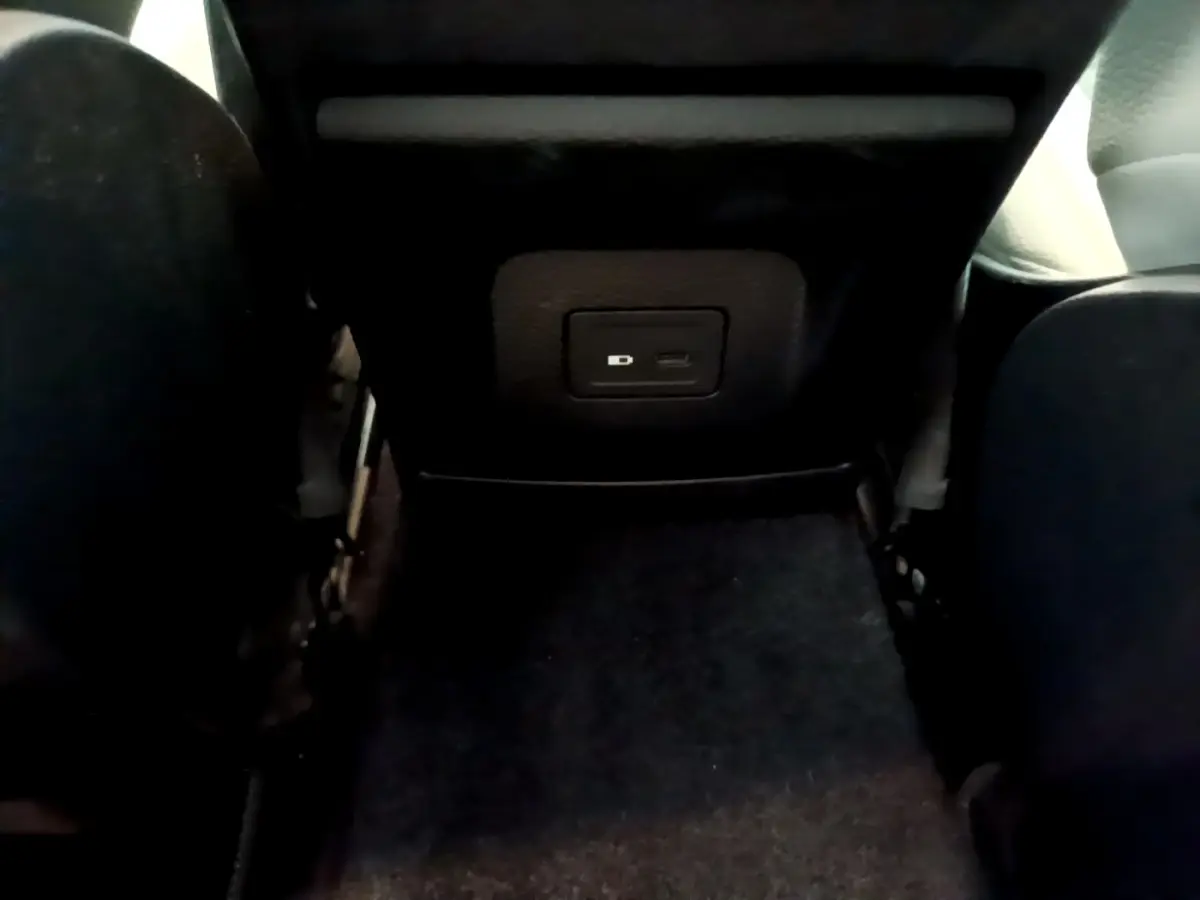 Vue rapprochée de la prise USB située à l'arrière des sièges noirs de la Mercedes Classe A Berline blanche.