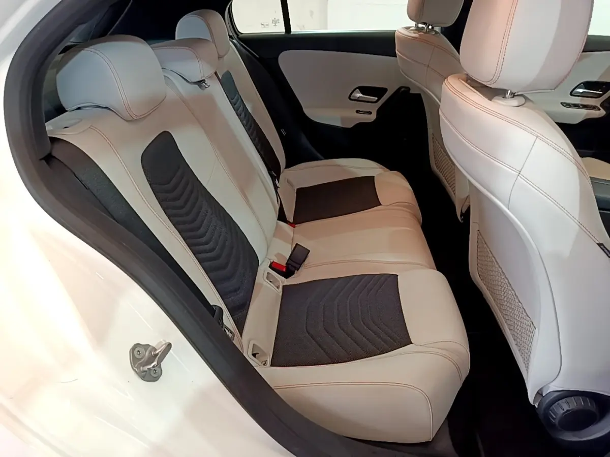 Vue intérieure côté droit des sièges arrière en cuir beige et noir de la Mercedes Classe A Berline A 250 e Business Line blanche.