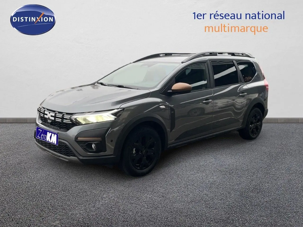 Dacia Jogger gris schiste métal en 3/4 avant droit avec jantes noires et rétroviseurs couleur cuivre.