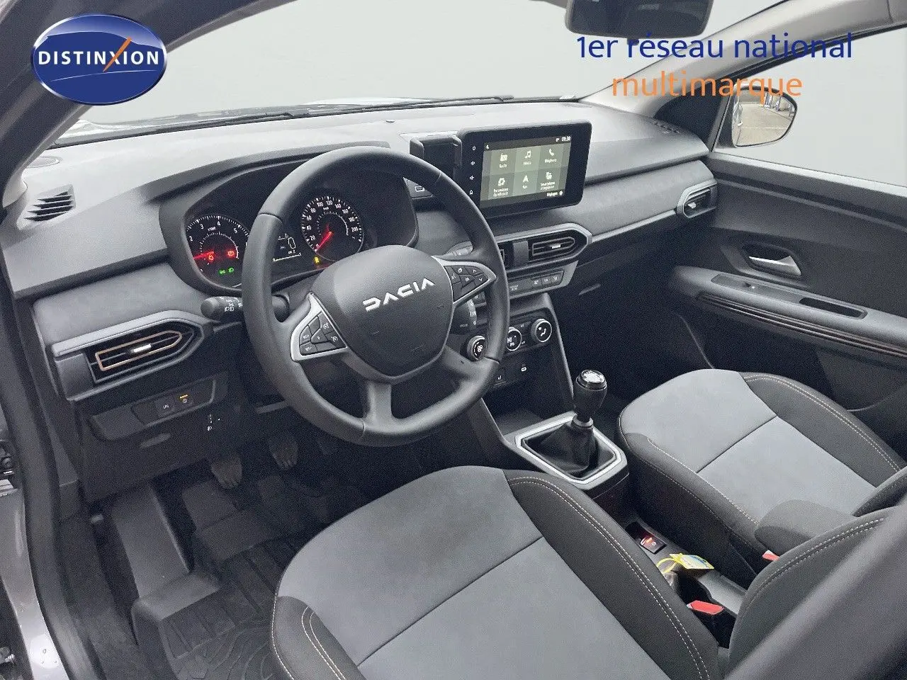 Vue latérale droite du Dacia Jogger gris schiste métal avec jantes noires et barres de toit, sur fond neutre.