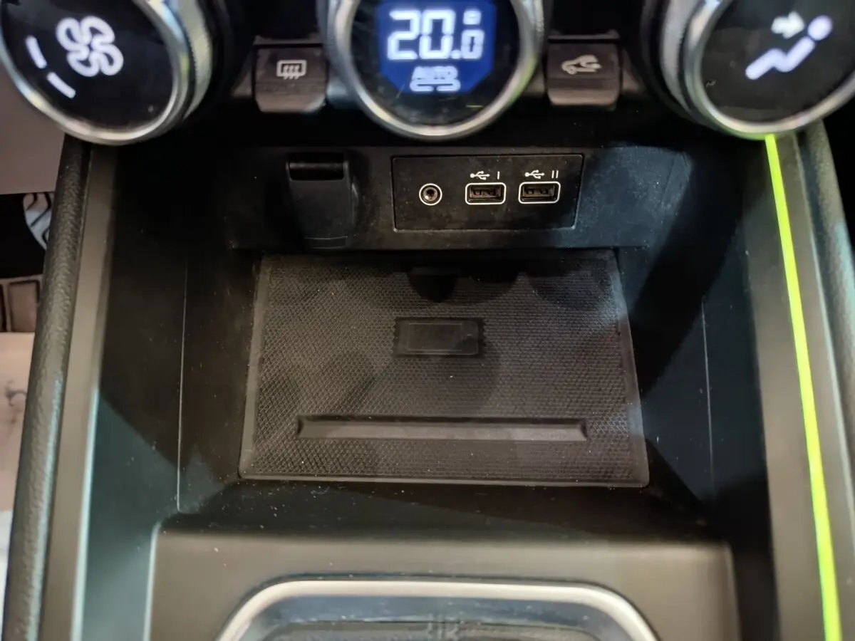 Vue rapprochée de la console centrale noire de la Renault Clio Techno TCe 90 avec ports USB et commandes de climatisation.