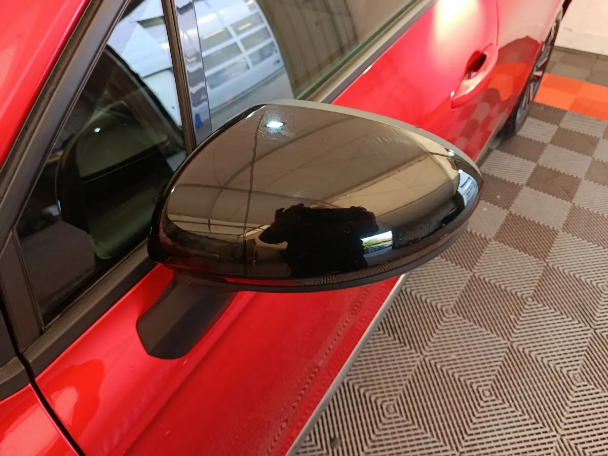 Rétroviseur droit noir en gros plan sur Renault Clio Techno TCe 90 rouge, vue côté droit avant.