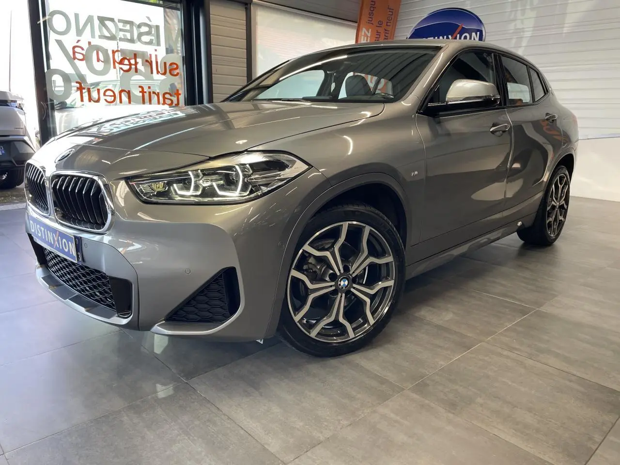 BMW X2 sDrive 18d M Sport X gris foncé vue 3/4 avant droit avec jantes 19 pouces style 722 M à rayons en Y.