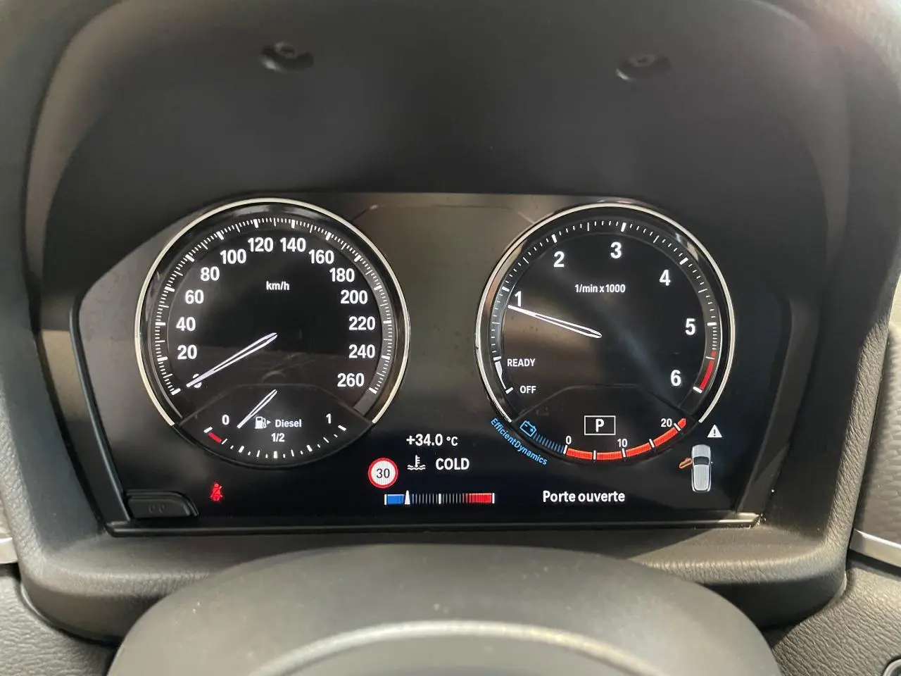 Vue rapprochée du tableau de bord numérique de la BMW X2 gris foncé, affichant compte-tours et vitesse en km/h.