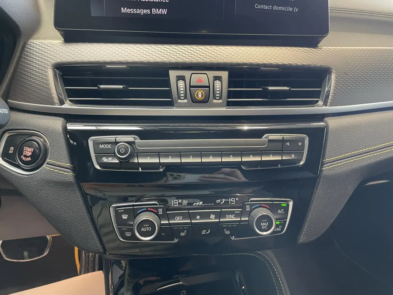 Vue rapprochée du tableau de bord de la BMW X2 M Sport X 2022, montrant la console centrale avec commandes climatisation et bouton Start/Stop.