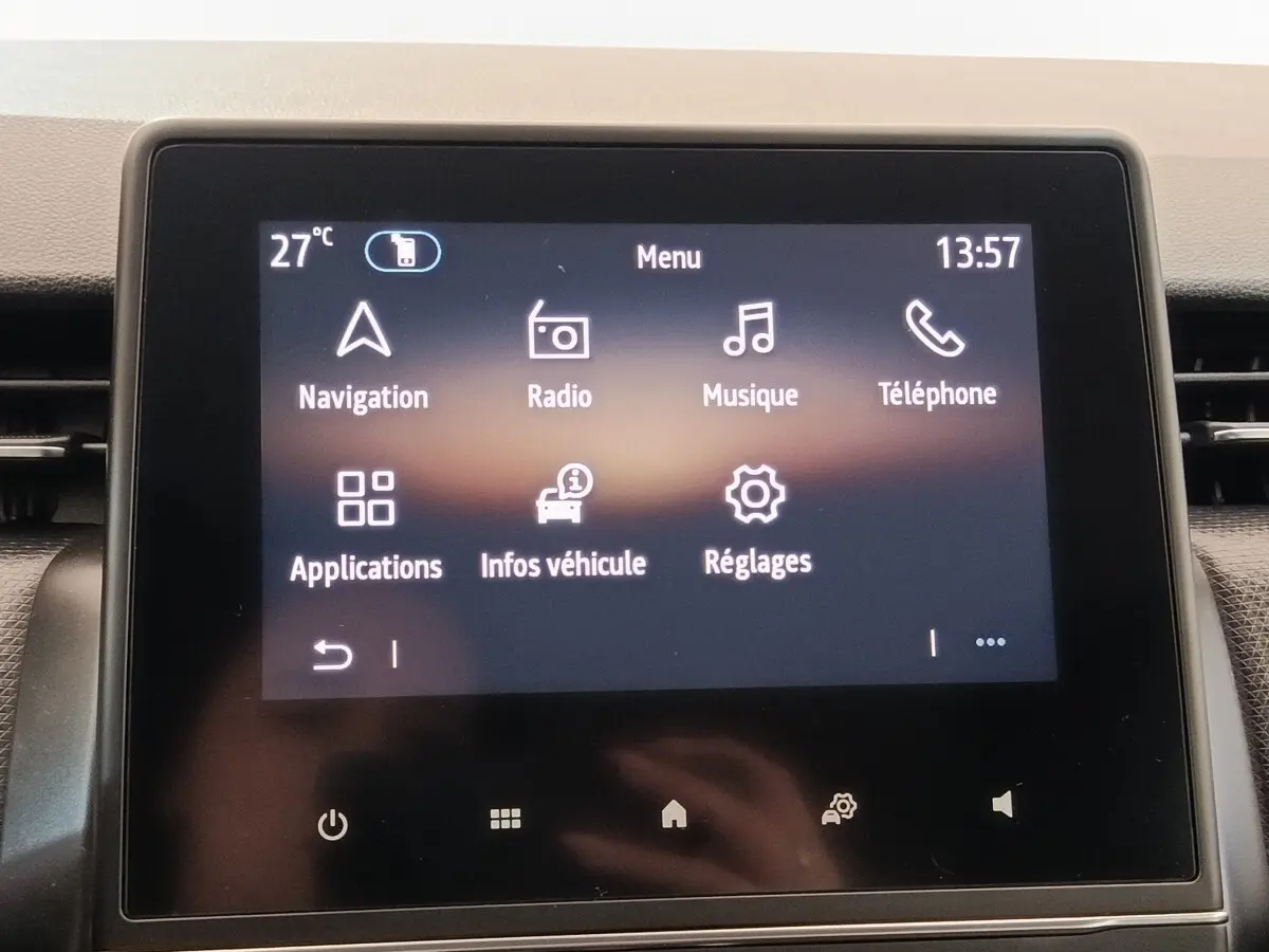 Écran tactile central de la Renault Clio Business blanc, affichant le menu principal avec navigation et radio.