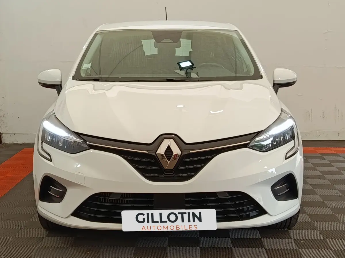 Vue avant d'une Renault Clio Business blanche avec phares LED allumés et calandre noire brillante.