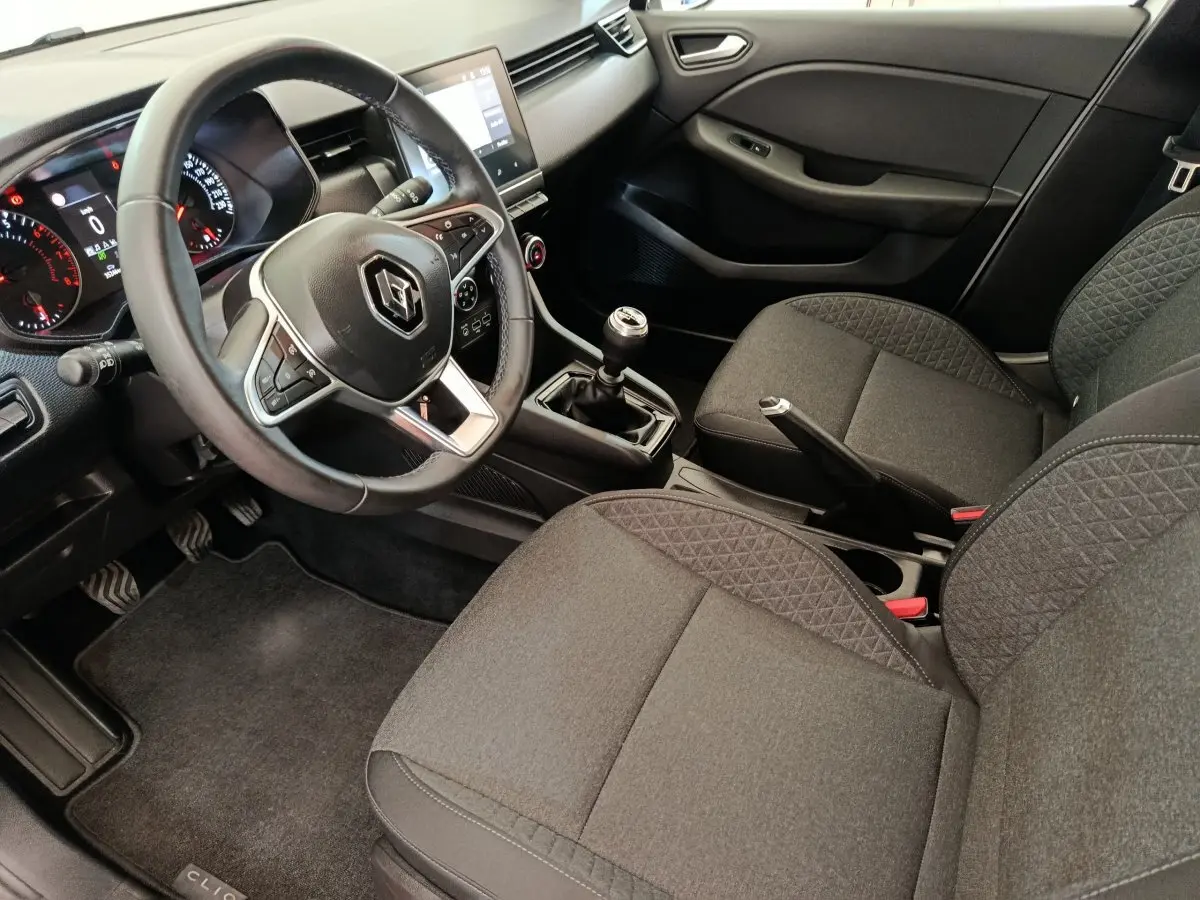 Vue intérieure côté conducteur de la Renault Clio Business TCe 100 GPL 2021, volant cuir et sièges tissu gris.