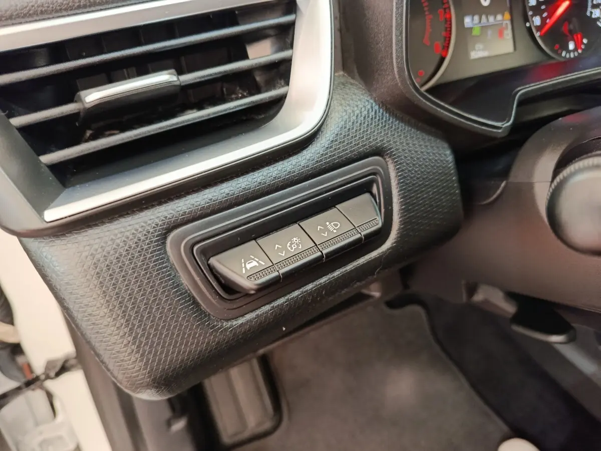 Détail intérieur côté gauche du tableau de bord de la Renault Clio Business blanc, avec commandes d’assistance à la conduite.