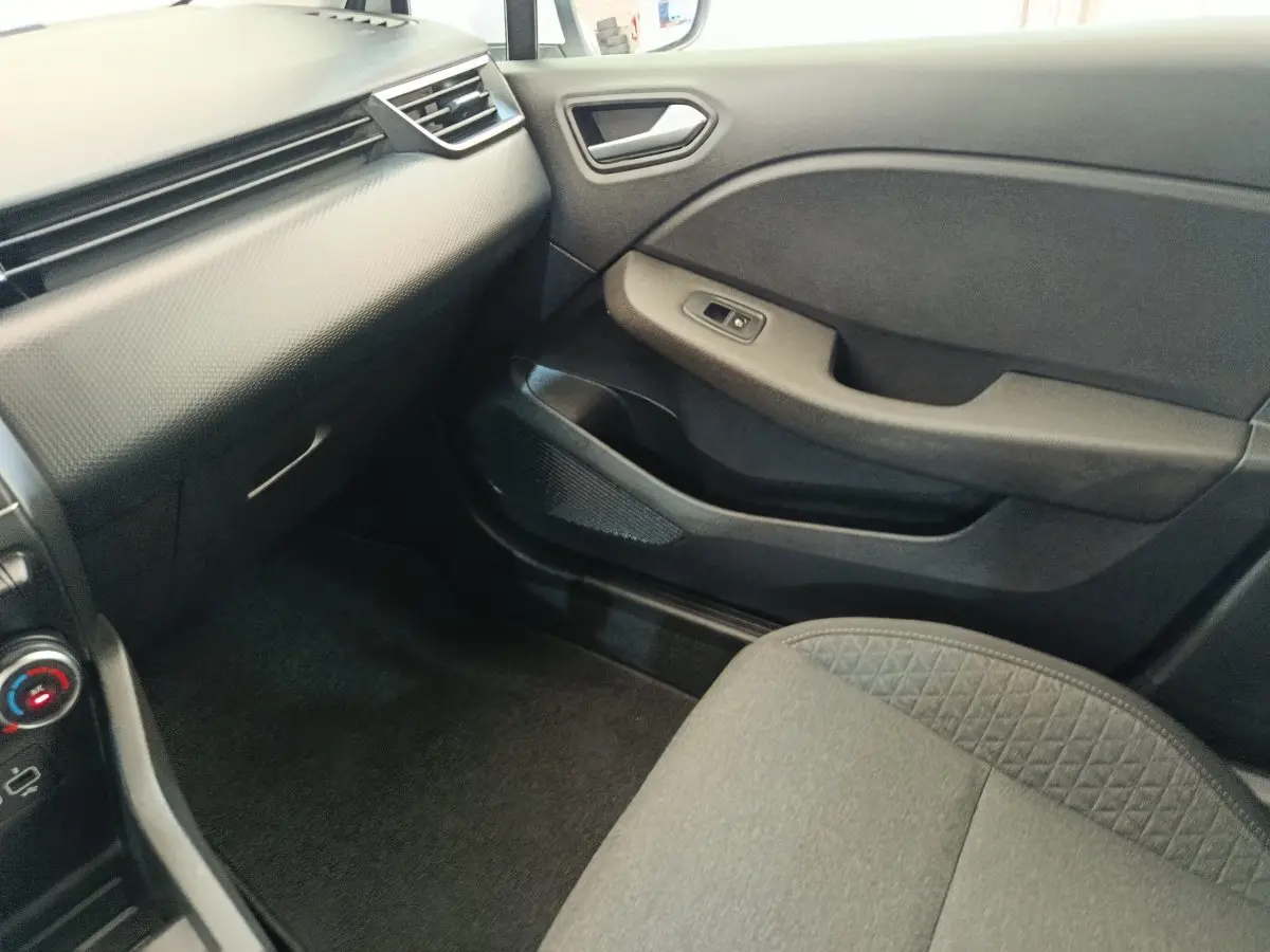 Vue intérieure côté passager avant de la Renault Clio Business TCe 100 GPL 2021 avec sellerie grise et tableau de bord noir.