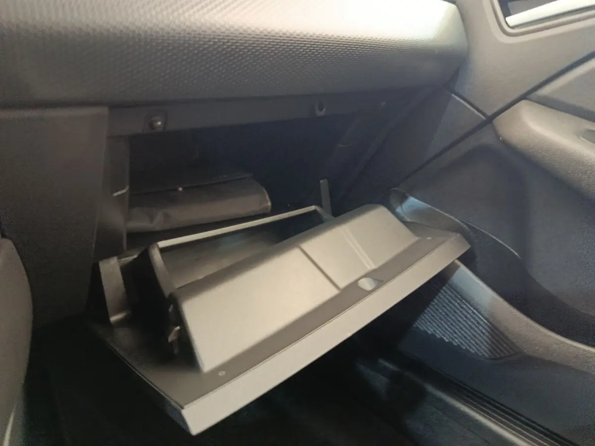 Gant de boîte à gants ouvert côté passager dans l’habitacle noir d’une Renault Clio Business blanc 2021.
