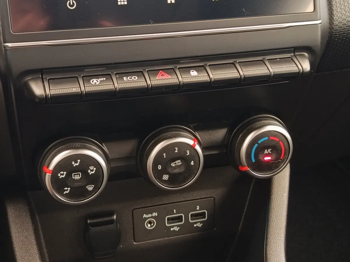 Vue rapprochée des commandes de climatisation et des ports USB de la Renault Clio Business TCe 100 GPL blanche de 2021.