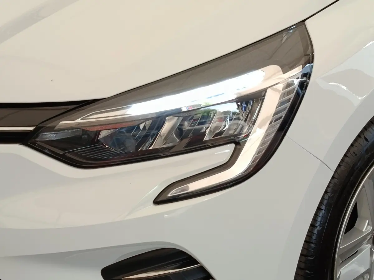 Gros plan sur le phare avant droit blanc de la Renault Clio Business TCe 100 GPL 2021 avec jante visible.
