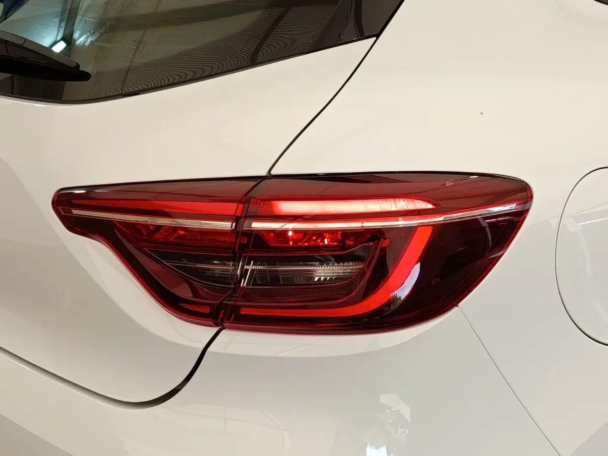 Gros plan sur le feu arrière droit rouge d’une Renault Clio Business blanc nacré, vue de côté arrière.