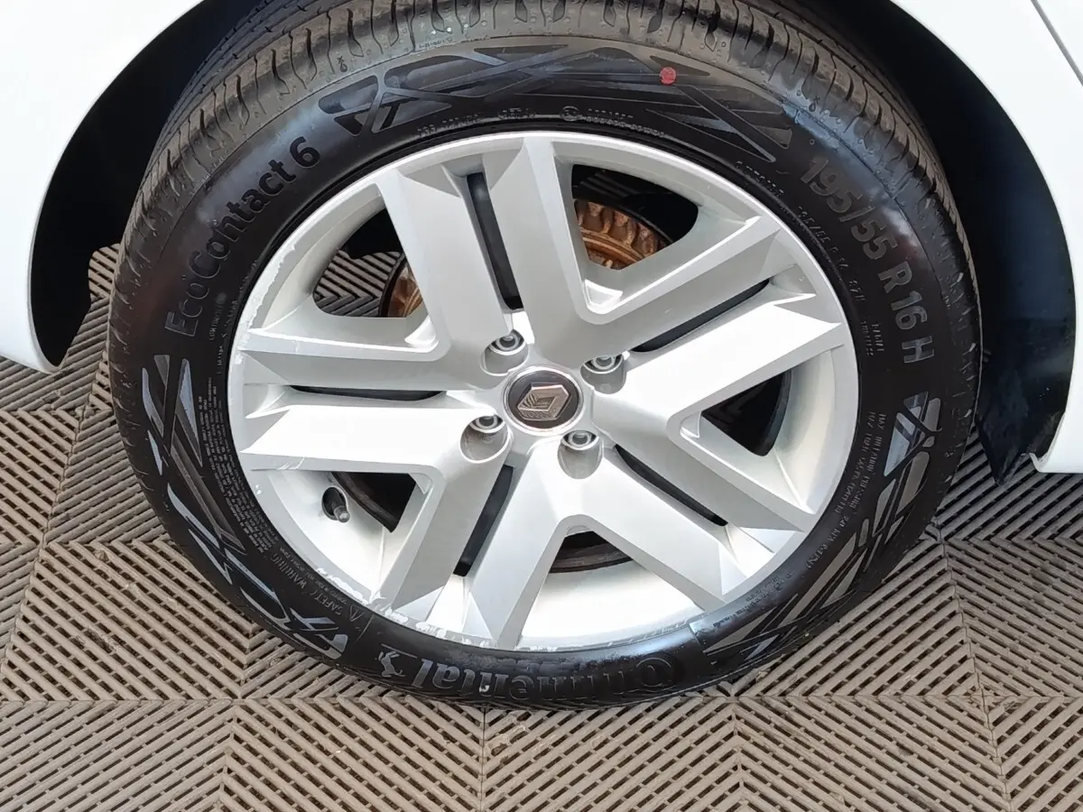 Gros plan sur la roue avant droite blanche d'une Renault Clio Business TCe 100 GPL avec jante alliage argentée.