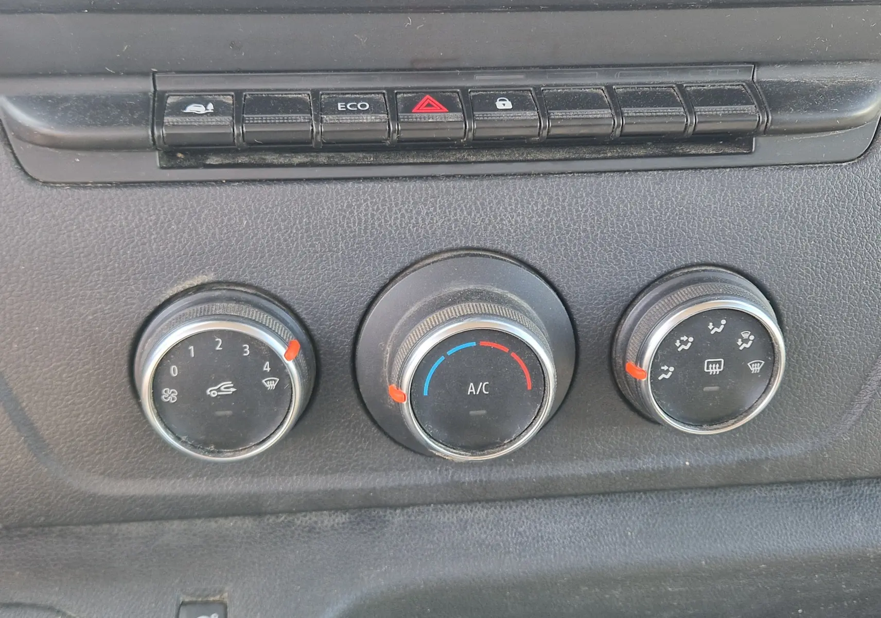 Gros plan sur les commandes de lève-vitres et réglage des rétroviseurs côté conducteur du Renault Master blanc.