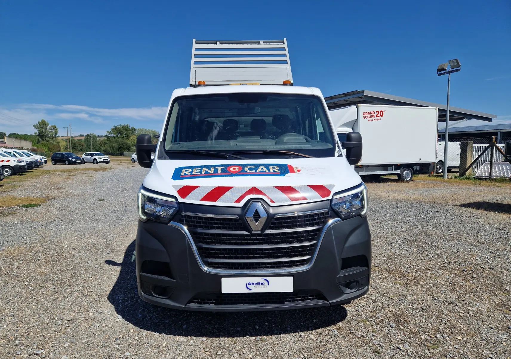 Vue avant d'un Renault Master Châssis double cabine blanc avec benne et coffre, marquage rouge et blanc sur le capot.