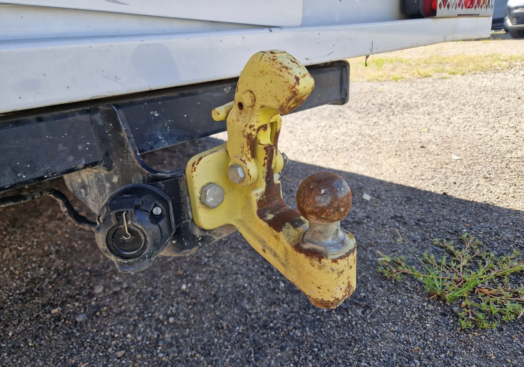 Gros plan sur l'attelage jaune rouillé fixé à l'arrière blanc du Renault Master Châssis Double Cab 2022.