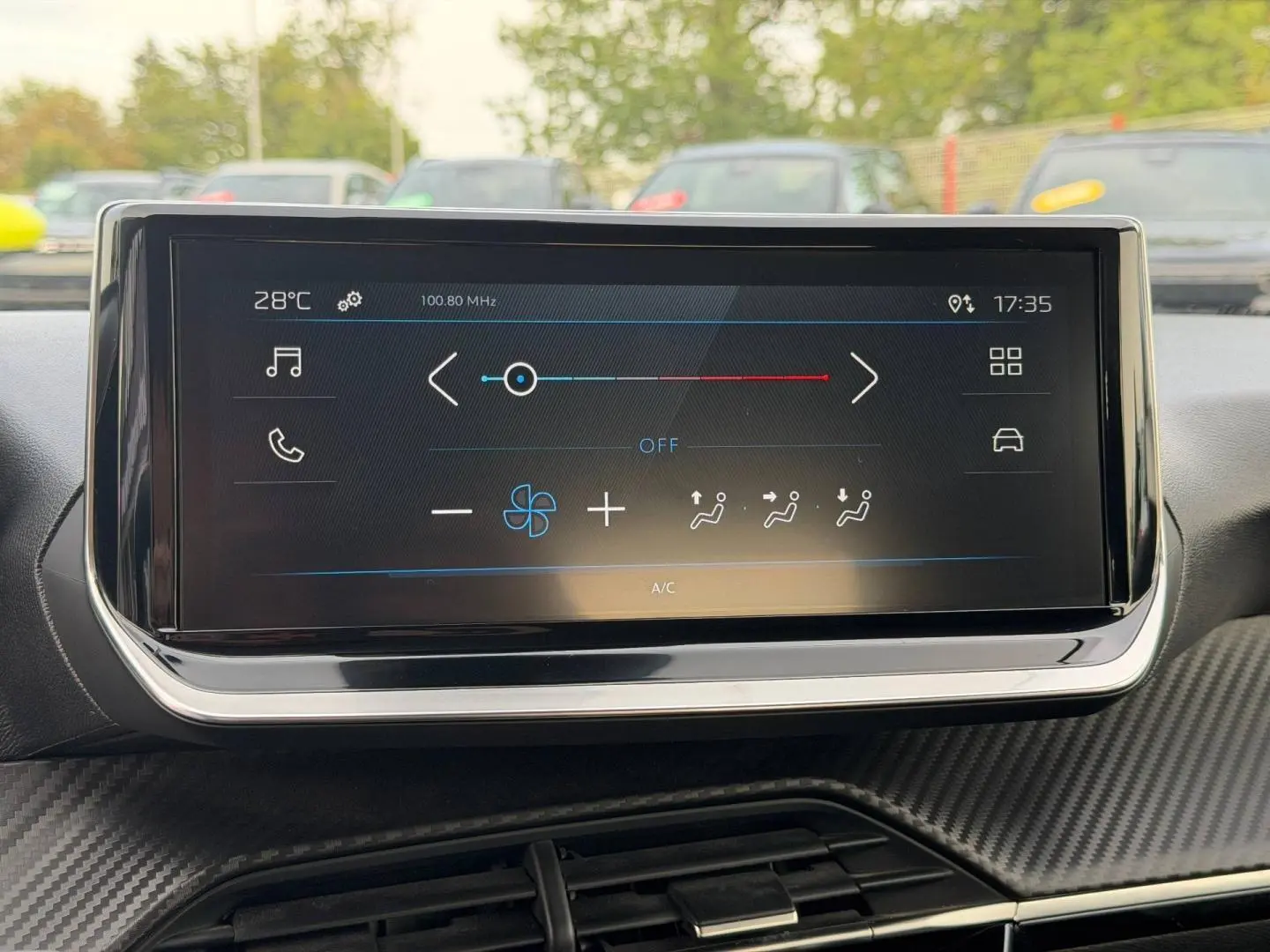 Vue intérieure centrée sur l'écran tactile multifonction du tableau de bord de la Peugeot 208 blanc Okénite.