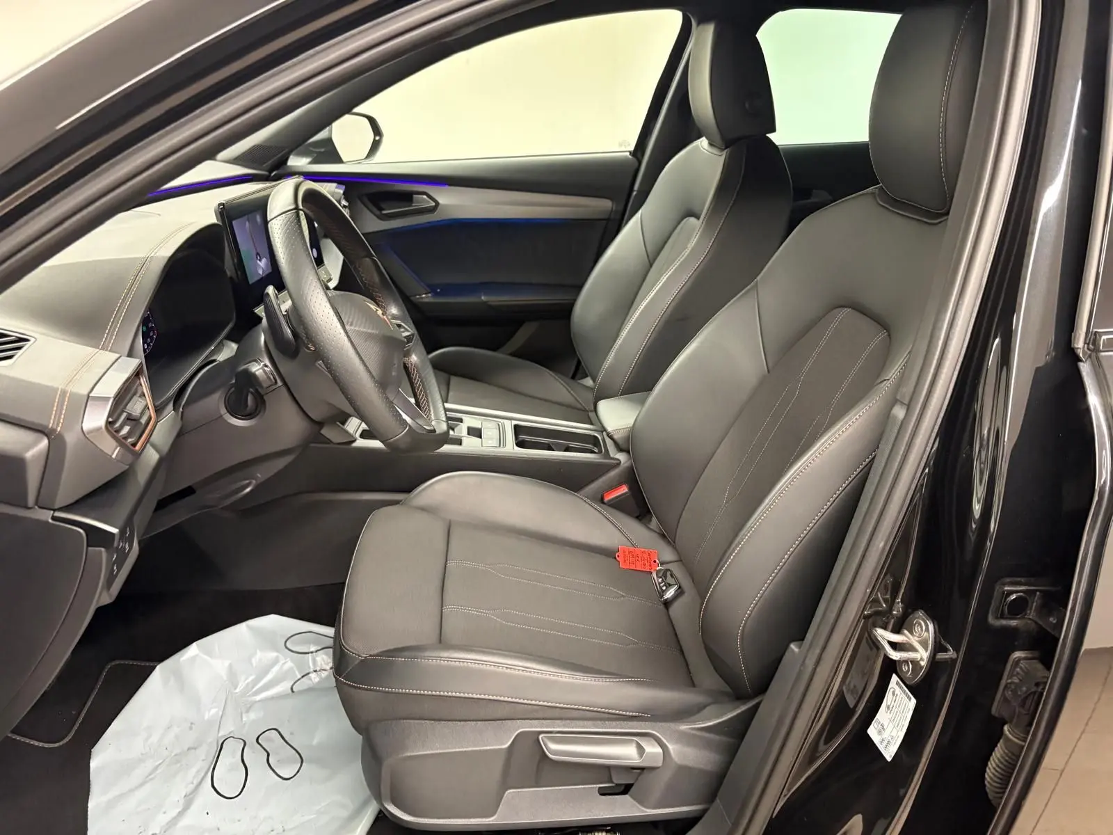 Vue intérieure côté conducteur de la CUPRA Formentor 1.5 TSI 2024 en noir minuit, sièges en cuir noir avec surpiqûres claires.