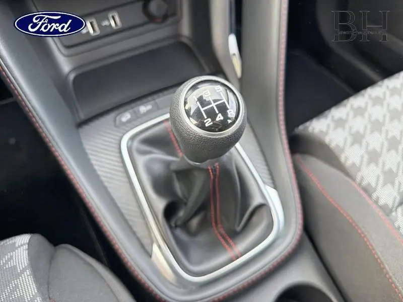 Le levier de vitesses manuel noir avec surpiqûres rouges dans l'habitacle d'une MG ZS Cosmic Silver.