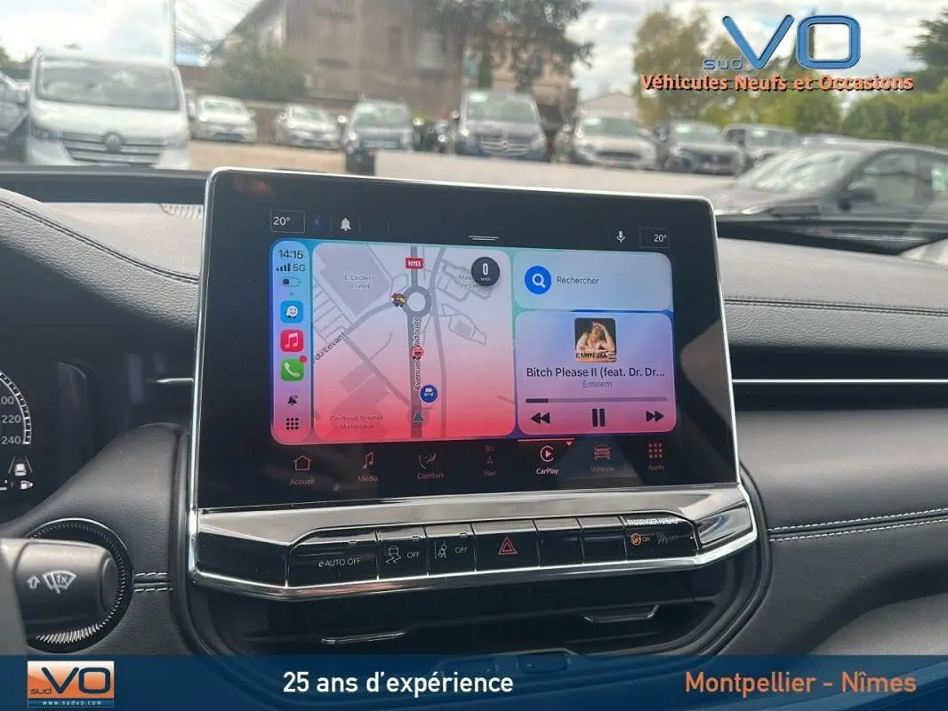 Vue rapprochée de l'écran tactile central du Jeep Compass 2023, affichant navigation et musique, intérieur noir.