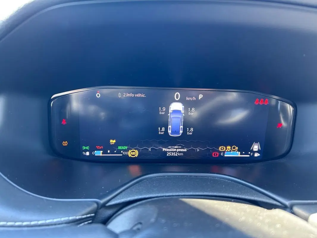 Vue rapprochée du tableau de bord numérique du Jeep Compass 2024 affichant la pression des pneus et les voyants d'alerte.