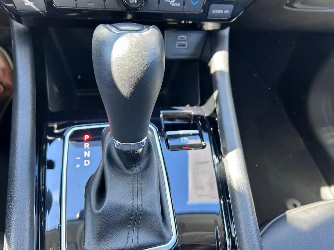 Gros plan sur la commande de boîte automatique noire du Jeep Compass 2024 avec indicateur de vitesse et frein de parking électronique.