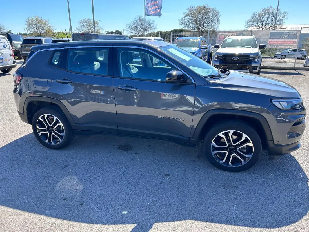 Vue de profil côté gauche d'un Jeep Compass gris 2024 avec jantes alliage 18 pouces et rétroviseurs noirs.