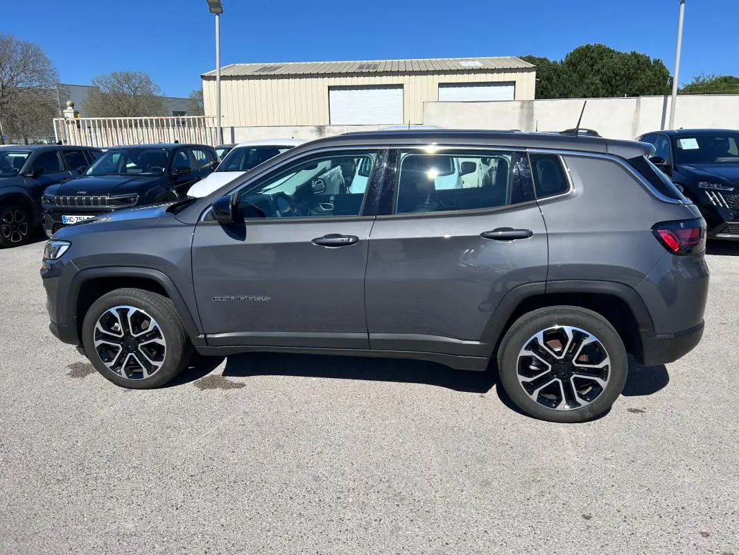 Vue latérale droite d'un Jeep Compass gris 2024 avec jantes alliage 18 pouces et toit noir contrasté.