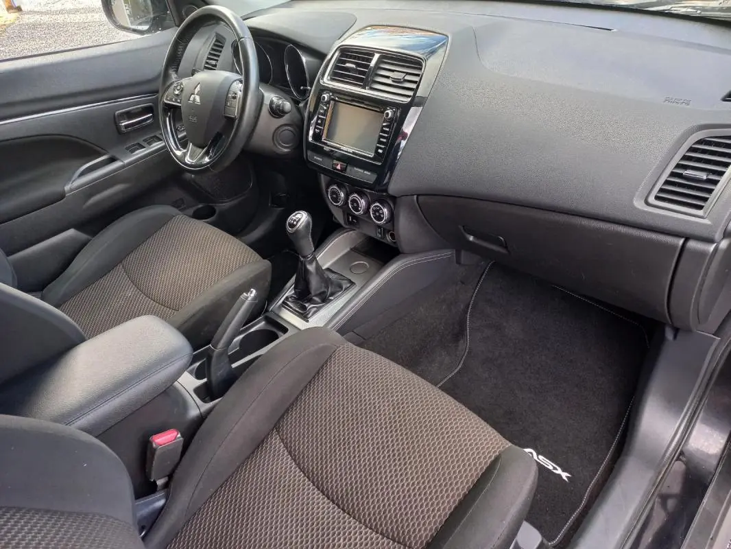 Intérieur noir du Mitsubishi ASX 2020 vu côté conducteur, avec tableau de bord, volant et levier de vitesses manuel.