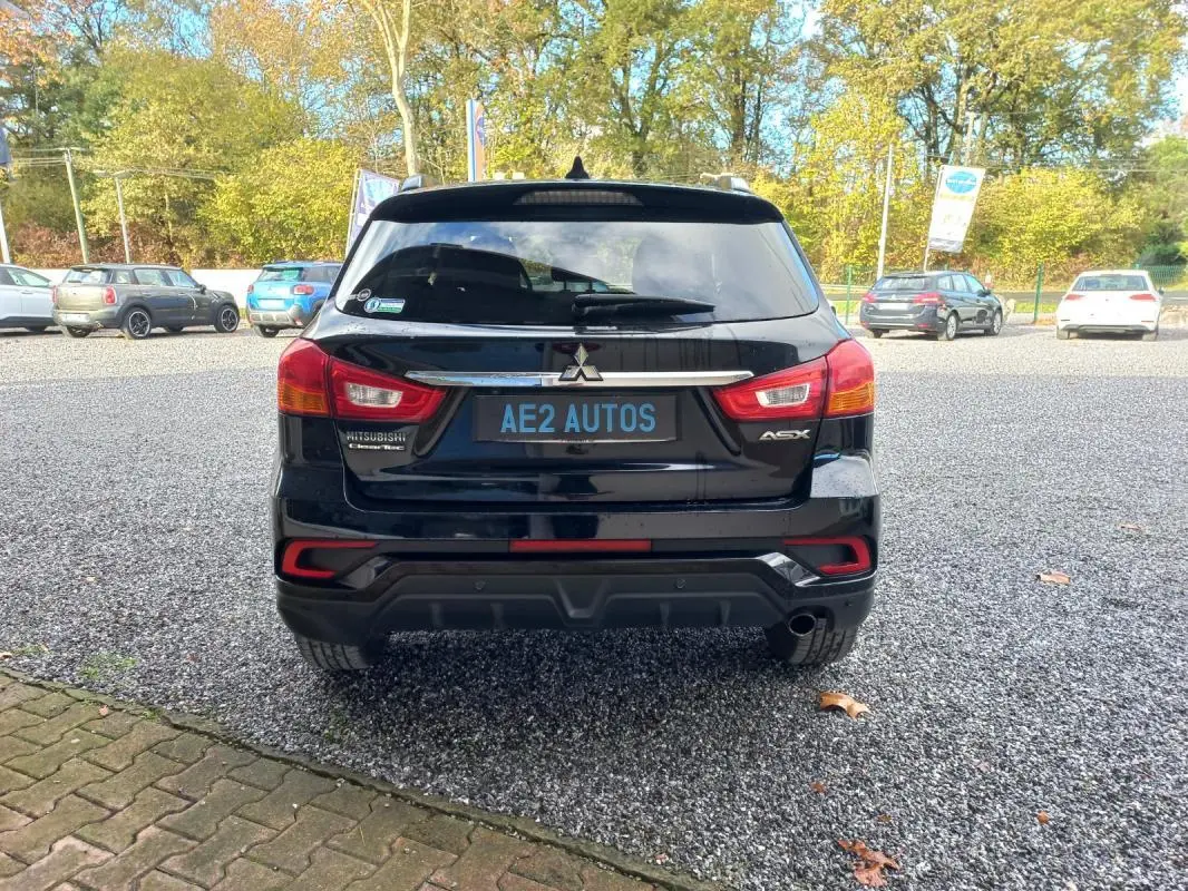 Vue arrière d'un Mitsubishi ASX Invite 2WD noir 2020, avec feux arrière et logo visibles sur un parking extérieur.