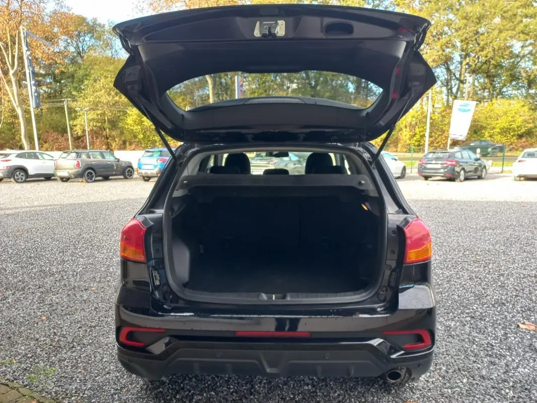 Vue arrière du Mitsubishi ASX noir 2020 avec coffre ouvert, feux arrière visibles et hayon levé en extérieur.