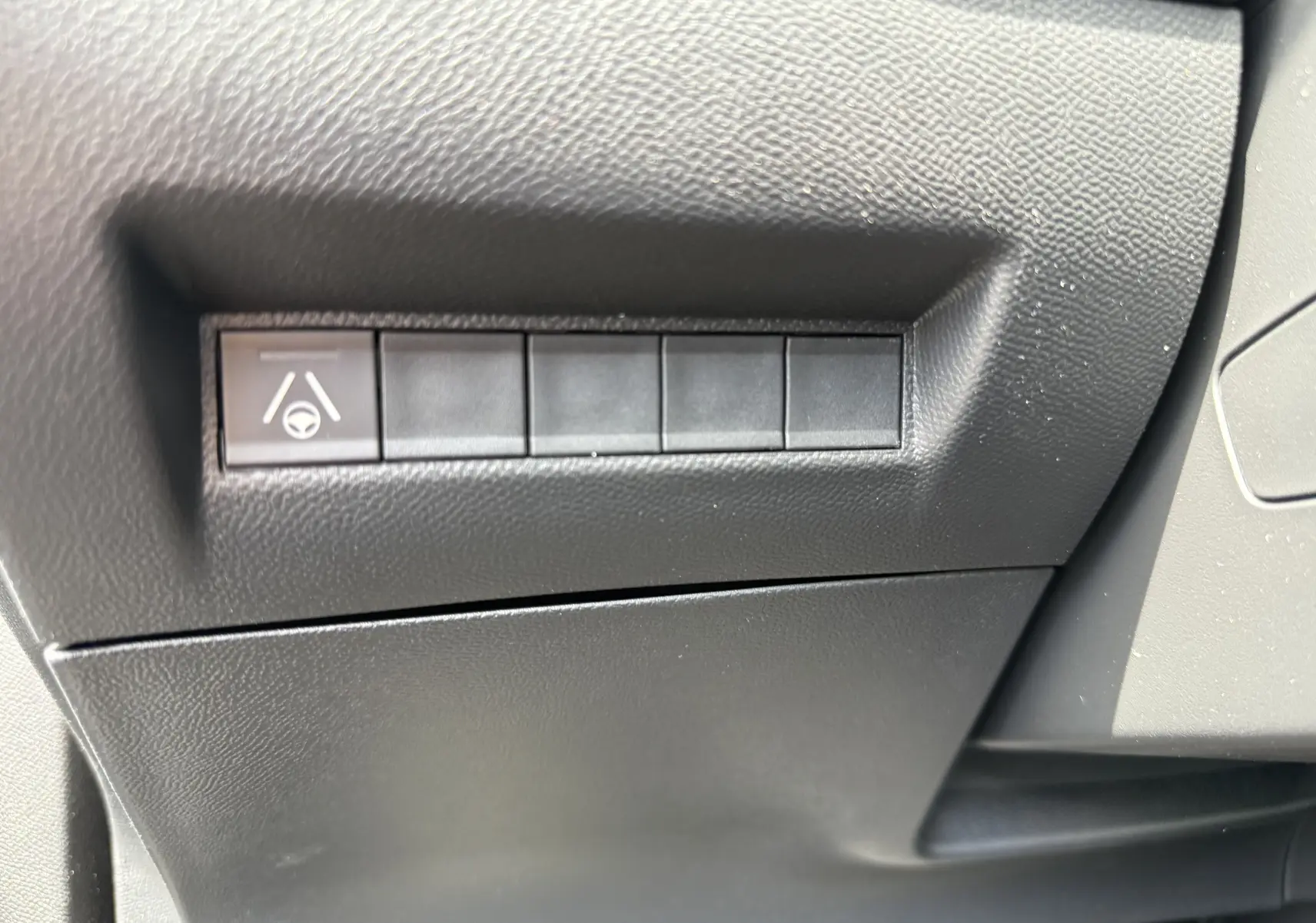 Gros plan sur le bouton d'assistance au maintien de voie dans l'habitacle noir du Peugeot 2008 Hybrid 145ch.
