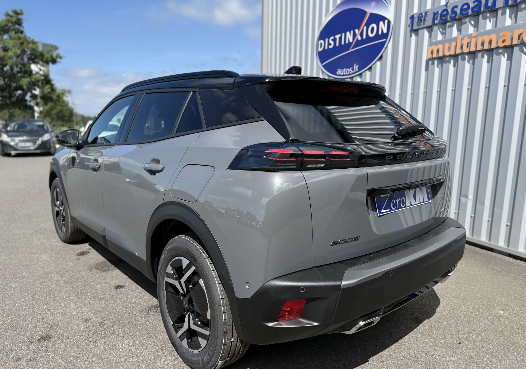 Vue 3/4 arrière droite d’un Peugeot 2008 hybride gris selenium avec toit noir et feux arrière LED distinctifs.