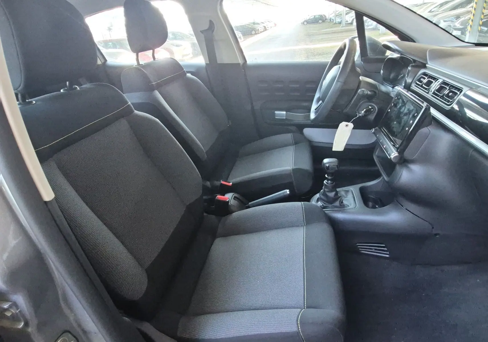 Intérieur avant de la Citroën C3 1.5 BlueHDi 2021, vue côté gauche montrant sièges tissu gris et tableau de bord avec écran tactile.