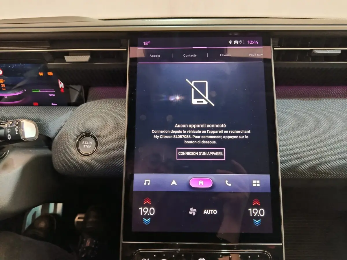Vue rapprochée de l’écran tactile central allumé dans l’habitacle d’une Citroën C5 hybride gris foncé, avec bouton Start/Stop visible.