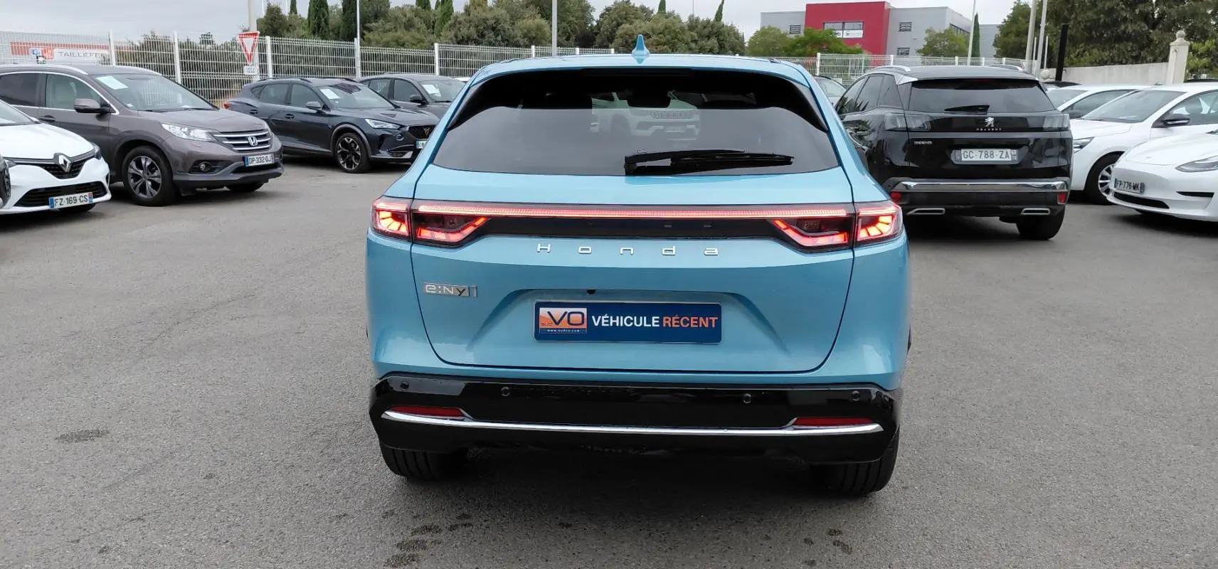 Vue arrière d'une Honda e:Ny1 Advance 204 ch bleu électrique 2025 avec feux LED et bande lumineuse continue.