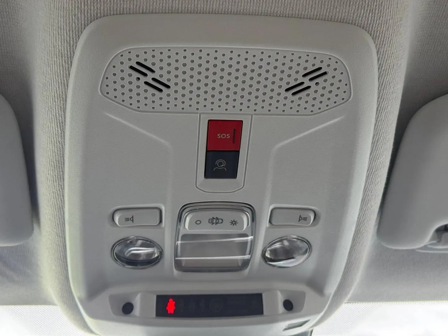 Vue en gros plan du plafonnier intérieur gris clair avec boutons SOS et éclairage de la Peugeot 208 noire.