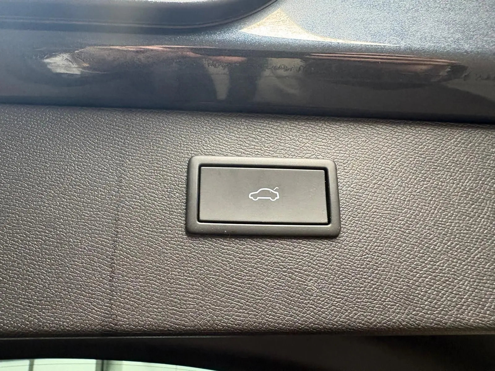 Bouton d'ouverture électrique du hayon sur la garniture intérieure d'un CUPRA Formentor gris magnétique, vue en gros plan.