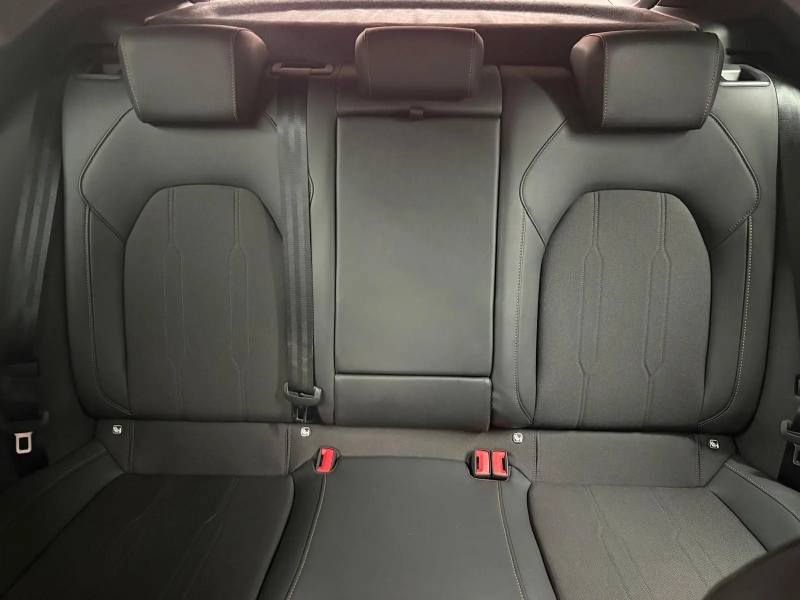 Vue rapprochée des sièges arrière en cuir noir du CUPRA Formentor 2024, soulignant les détails de couture et les ceintures de sécurité.