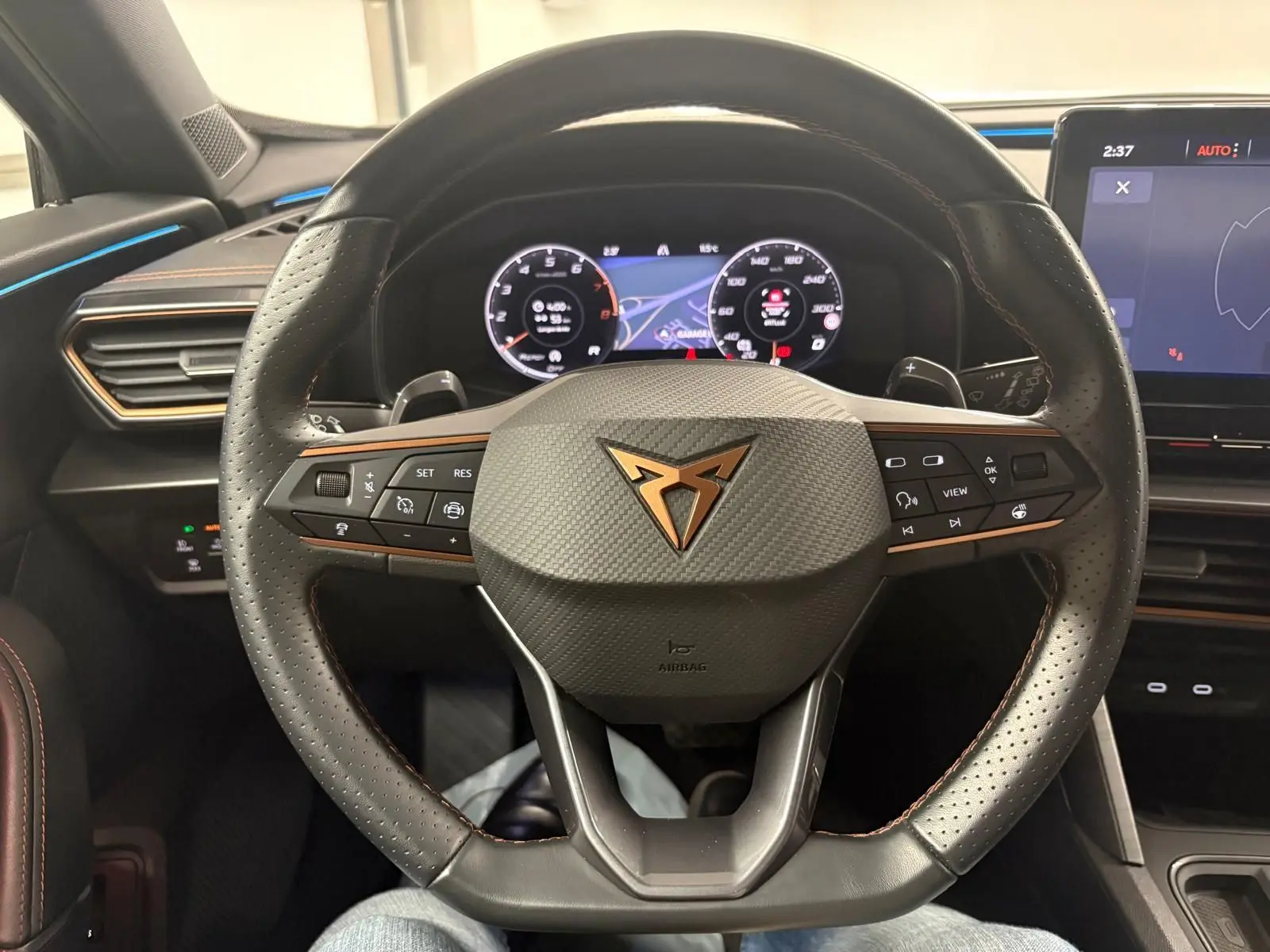 Vue rapprochée du volant en cuir perforé noir avec logo CUPRA cuivré et tableau de bord numérique du Formentor 2024.