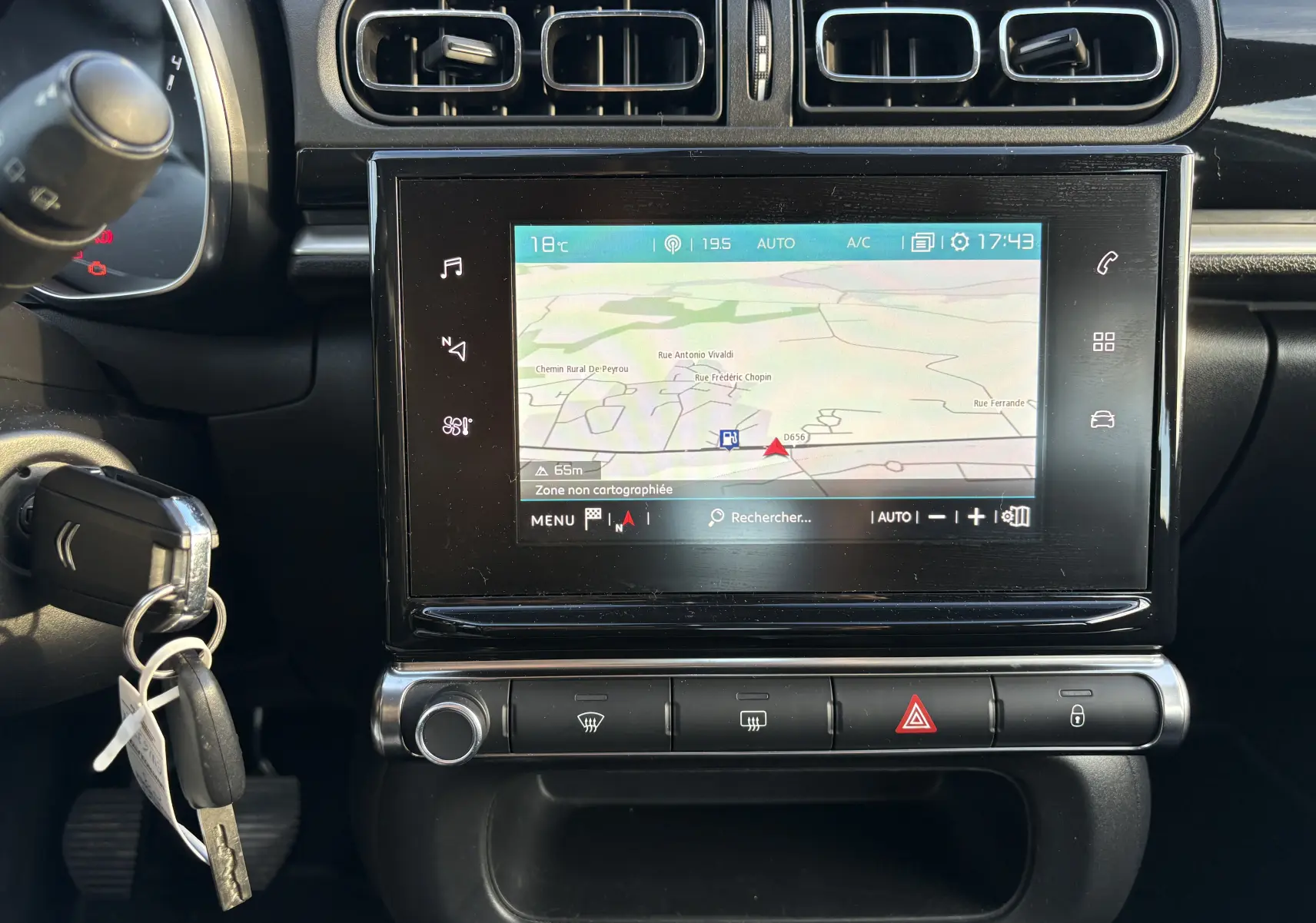 Vue rapprochée de la console centrale de la Citroën C3 rouge 2018 avec écran tactile affichant la navigation GPS.