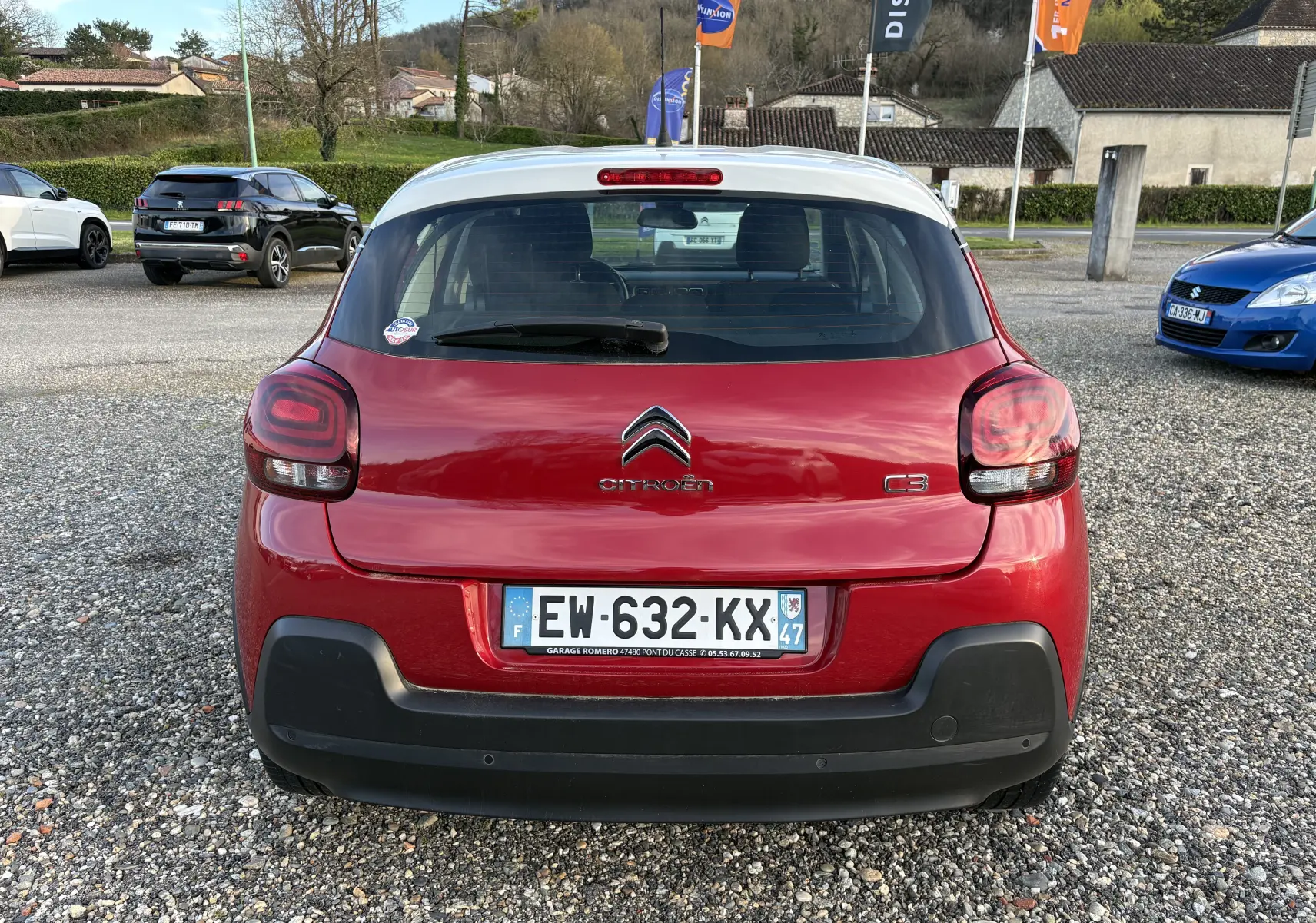 Vue arrière d'une Citroën C3 rouge 2018 avec toit blanc, feux arrière arrondis et pare-chocs noir contrastant.