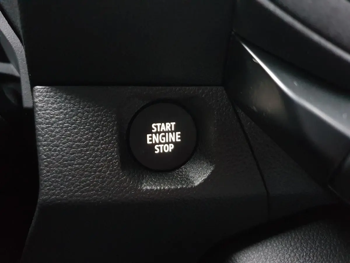 Gros plan sur le bouton Start Engine Stop noir dans l’habitacle du Dacia Duster blanc glacier 2025.